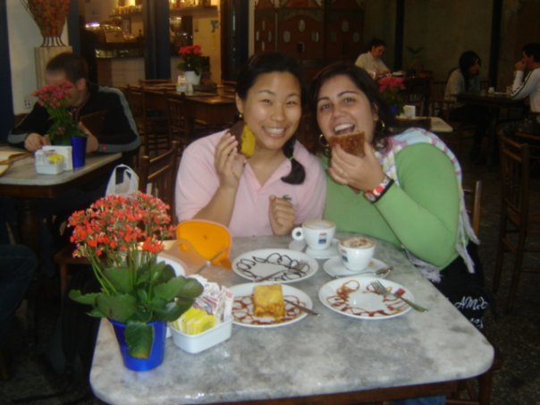 Daniela Pescuma and her friend who inspired Lisa laughing together over cake and coffee at a café