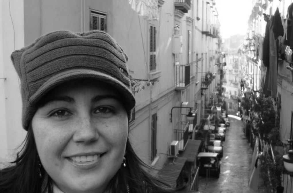Dani standing above a narrow Napoli street (vicolo) in the Quartieri Spagnoli, lined with balconies and washing lines