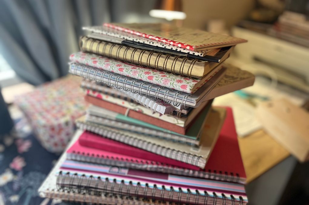 A stack of colourful notebooks piled on a table